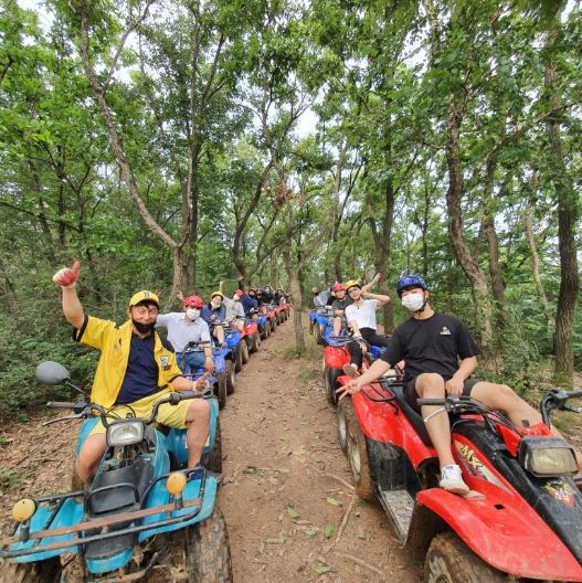 Visitors riding ATVs on a forest trail